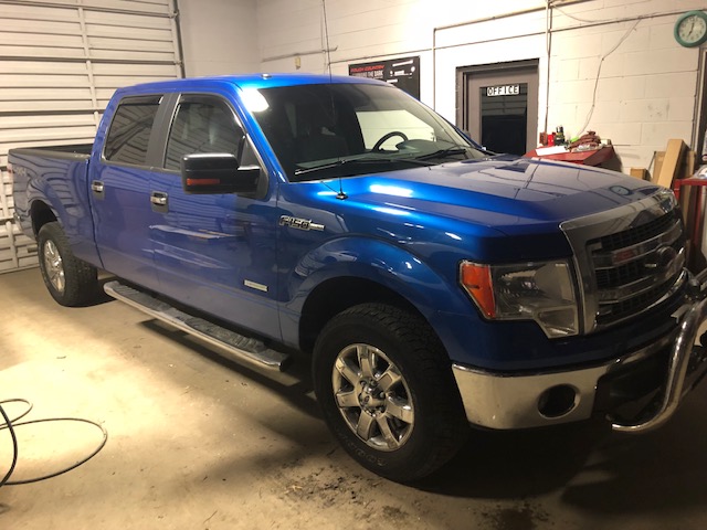 Blue Ford truck in service bay